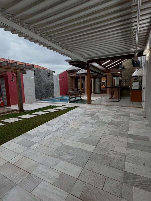 Área coberta com piso claro e gramado