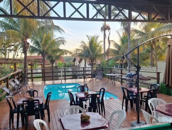 Área coberta com mesas ao lado da piscina